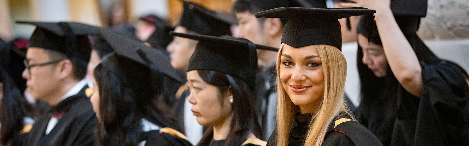 Students wearing graduation cap and gown.